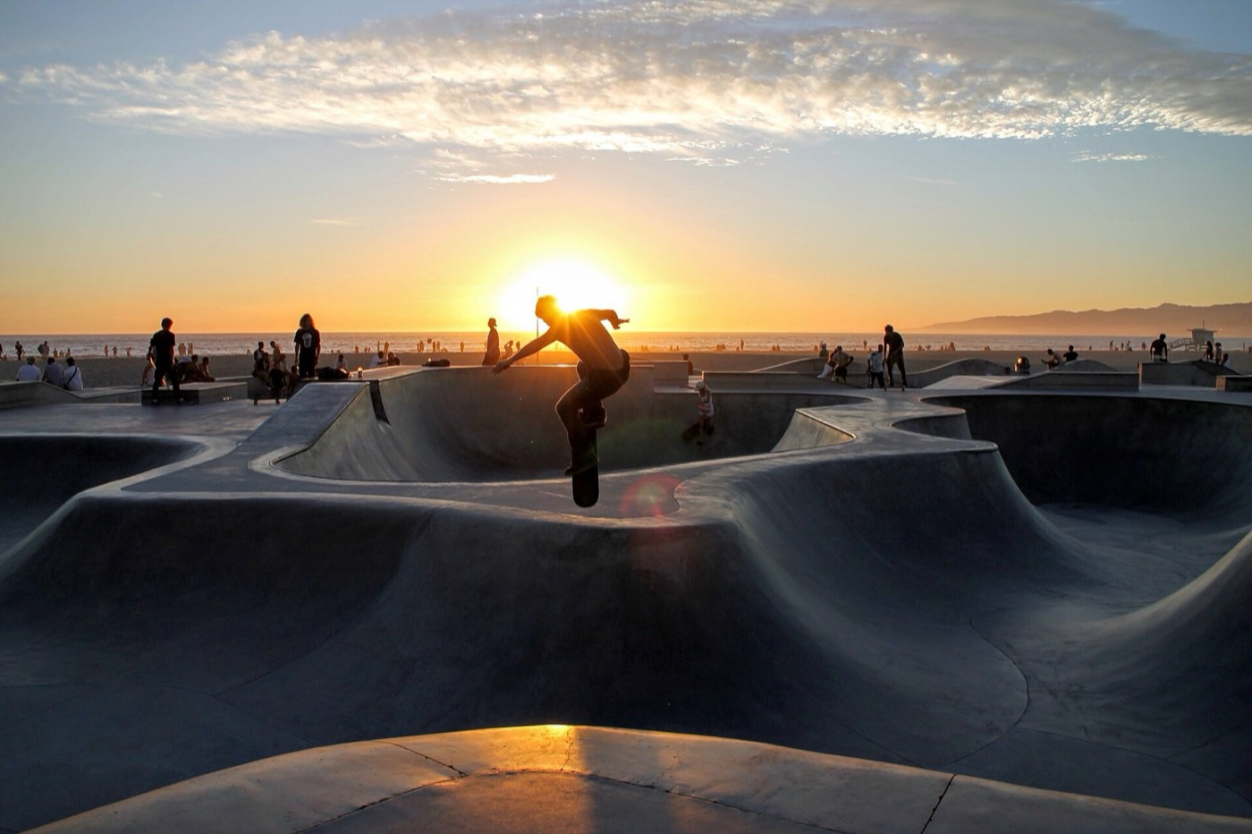 A skater airs out of a bowl at Venice Skatepark at sunset